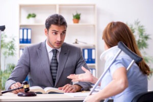 An injury victim with a neck brace and a crutch discussing her case with an experienced personal injury lawyer in Huron.