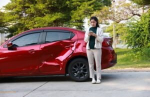 A woman standing by her vehicle after a crash and wondering, “Do I have to file a police report after a car accident?”